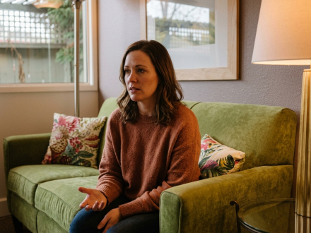 Woman sitting on couch discussing her relationship issues